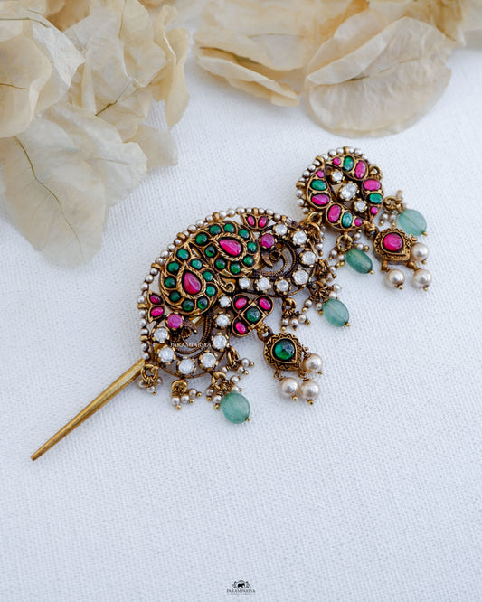 Crafted with pure silver and micron gold plating, the Yazu Hairpin is a versatile piece that adds elegance to any hairstyle. Its multi-use design allows it to also be used as a pendant, adorned with kundan and moissanite stones for a touch of luxury. Elevate your look with this exquisite hair accessory.