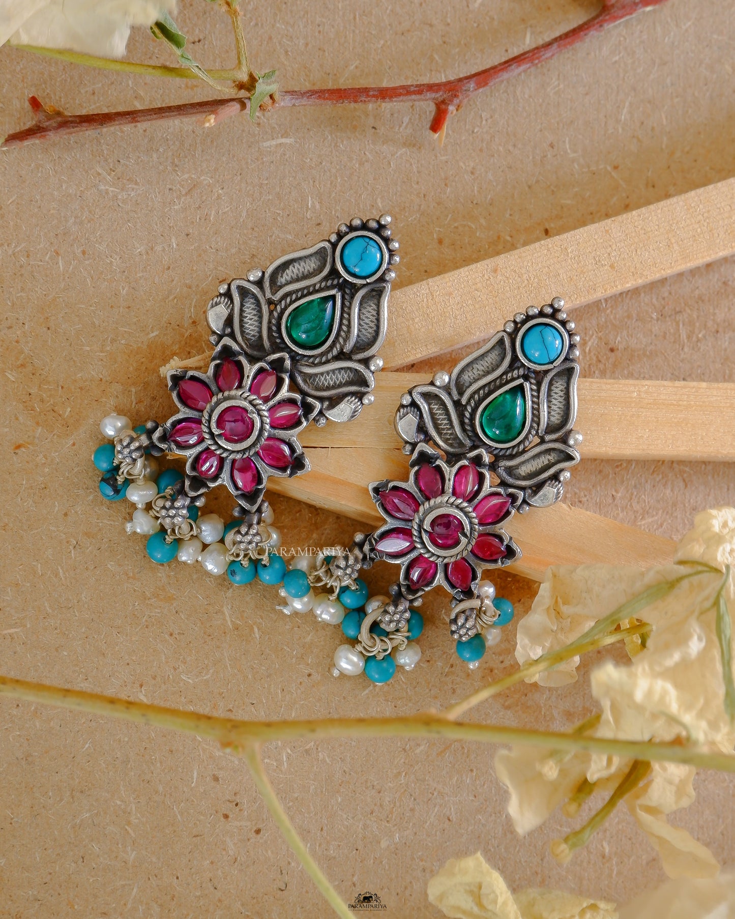 These Lunar Earrings will make any ensemble shine. The simple ear studs come adorned with beautiful rani pink kemp and turquoise stones, adding a touch of class to any outfit.
