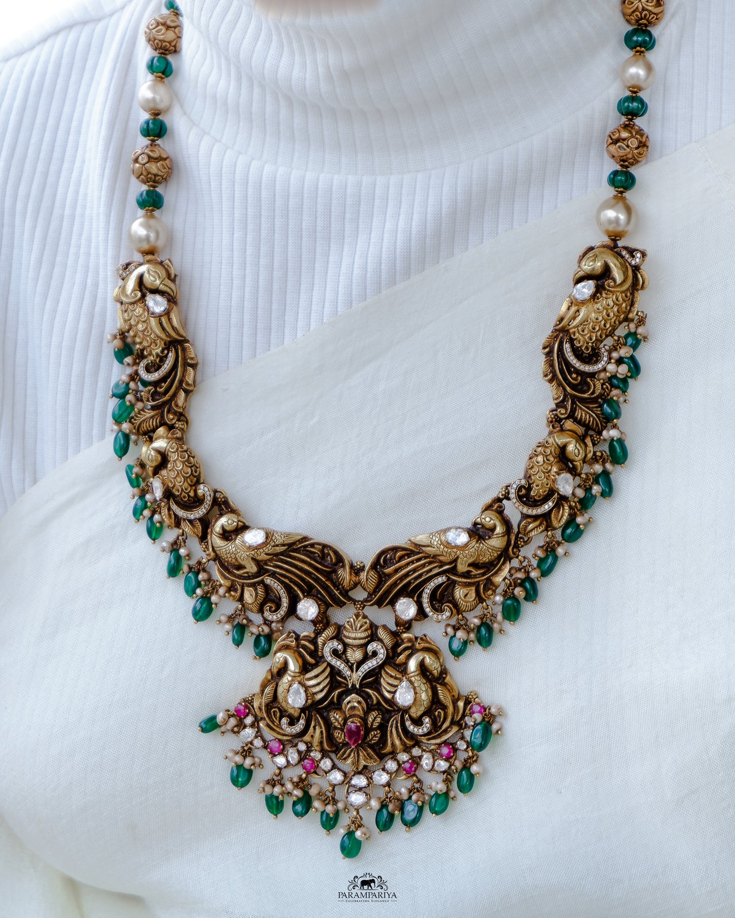This eye-catching Gavi Necklace will make a statement! Crafted with 92.5 pure silver gold micron plated temple nakshi and adorned with moissanite and zircon stones, semi precious beads, and fresh water pearls, it's sure to elevate your look.