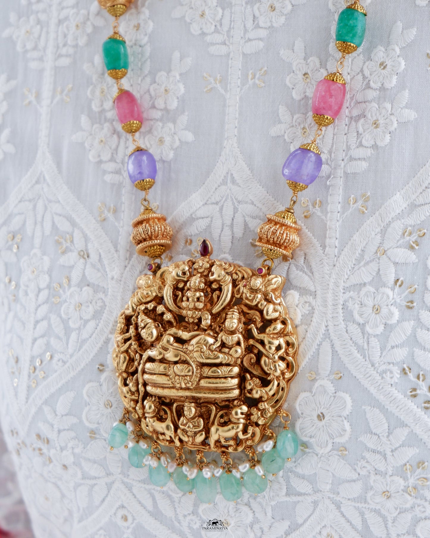 This Vish Necklace is expertly crafted from 92.5 pure silver with antique gold micron plating and adorned with semi-precious beads. It features intricately carved depictions of Lord Vishnu and Goddess Lakshmi, making it a bold statement piece.