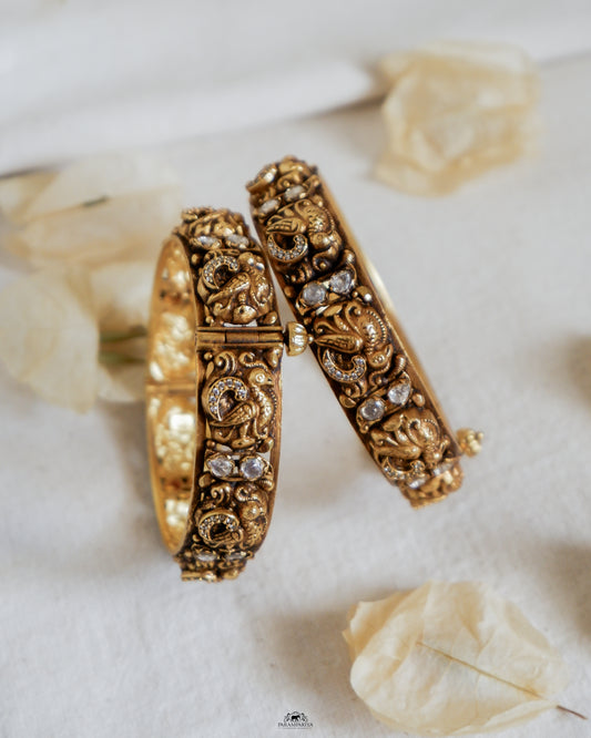 Elevate your look with Viana Bangle, a chic pair of 92.5 pure silver, micron gold plated temple bangles adorned with sparkling moissanite stones.