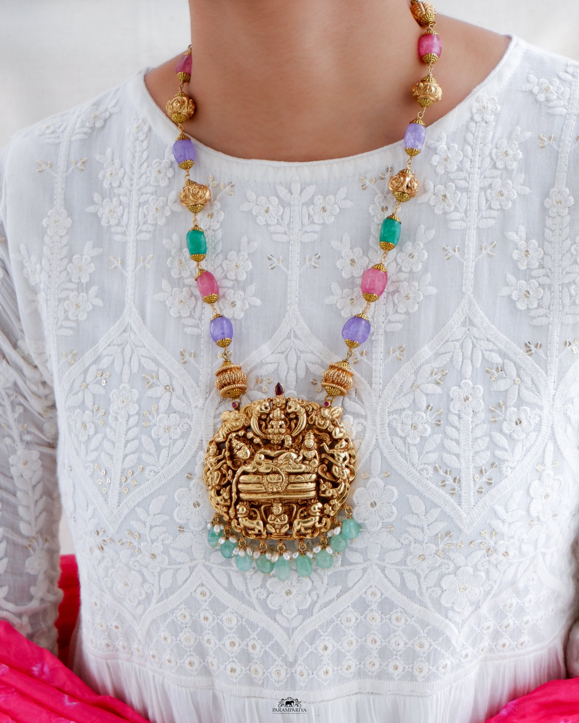 This Vish Necklace is expertly crafted from 92.5 pure silver with antique gold micron plating and adorned with semi-precious beads. It features intricately carved depictions of Lord Vishnu and Goddess Lakshmi, making it a bold statement piece.