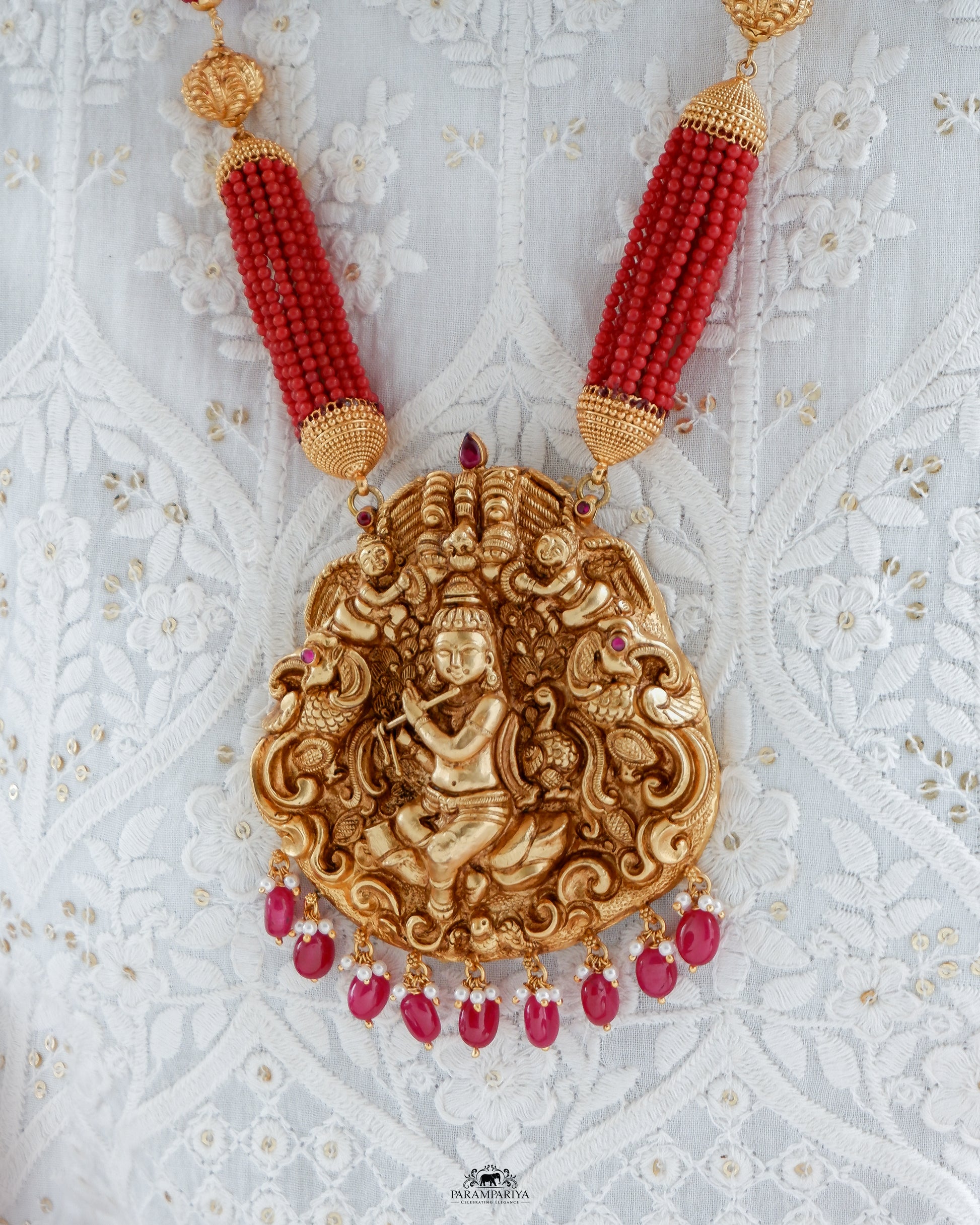 Uncover an artfully crafted unisex necklace adorned with an intricate charm of Lord Krishna and corals on www.parampariya.in. This exquisite jewel is made from pure silver and plated with antique gold microns for a beautiful finish.