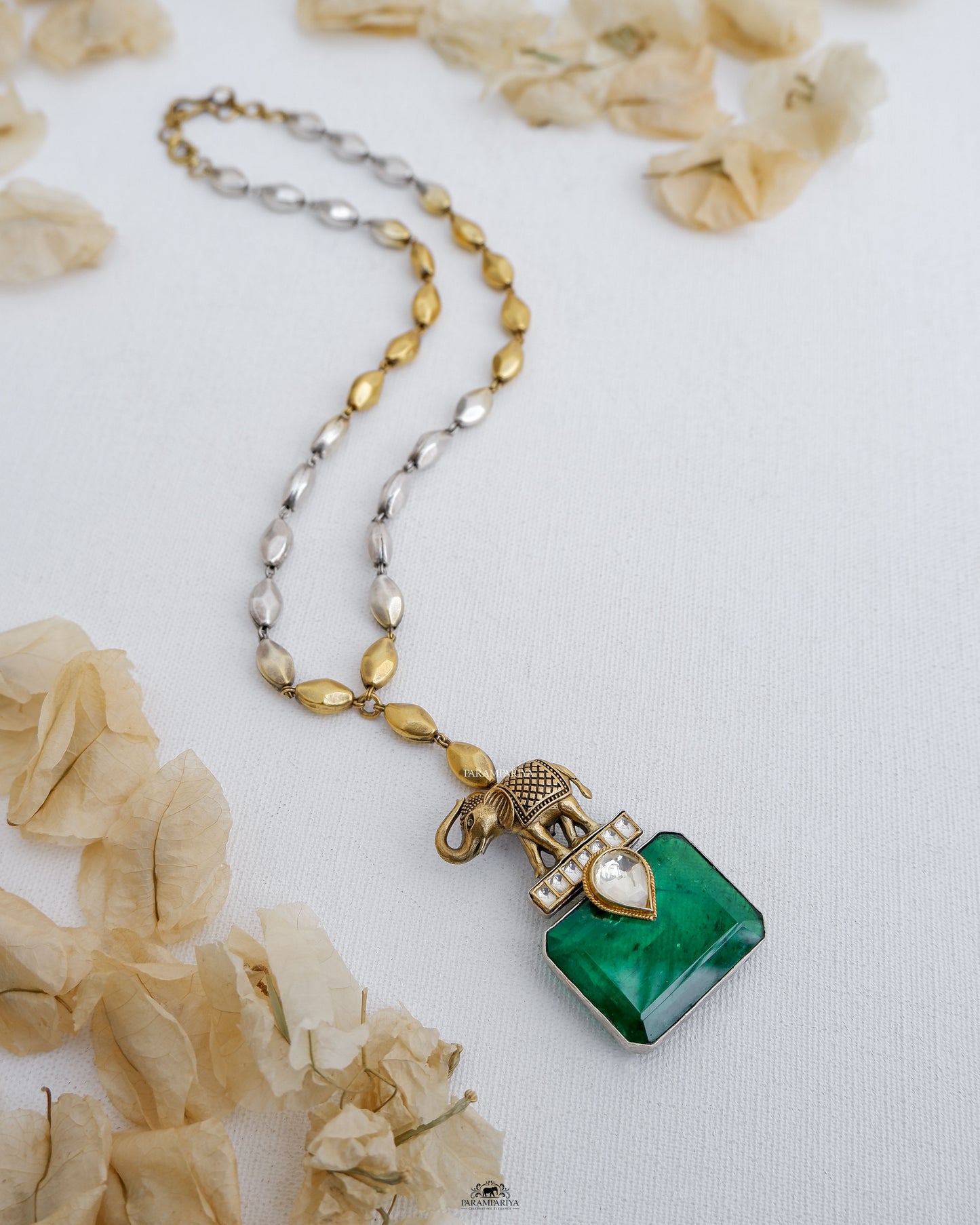 This stunning piece features a beautiful elephant design, adorned with a sparkling green doublet stone. Crafted with pure silver and dual tone plating, this necklace makes a statement of elegance and sophistication.