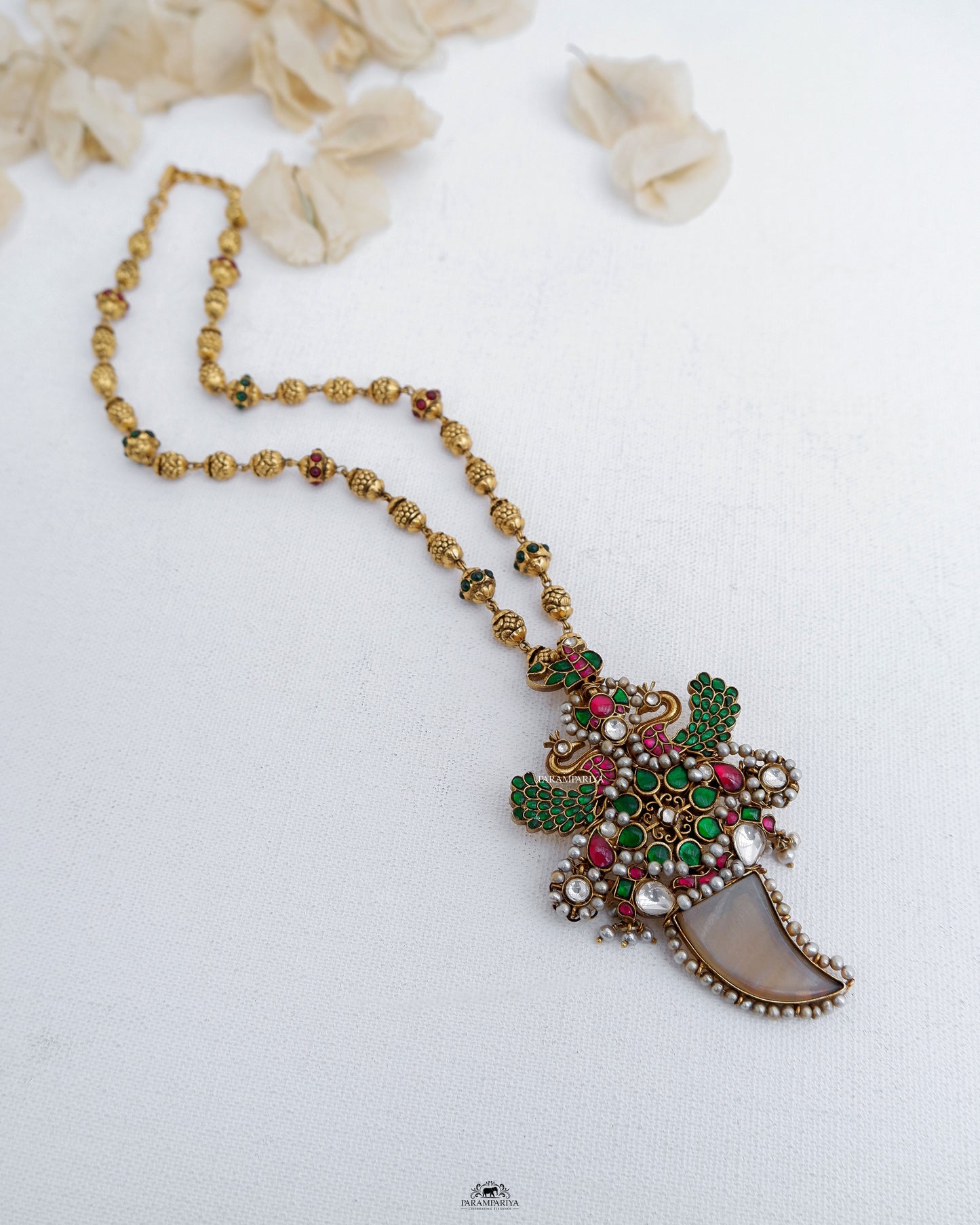 This Nithra Necklace features a pure silver micron gold plated kundan pendant adorned with gold beads, maintaining a vintage and unique appeal.