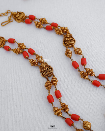 This temple necklace features a depiction of goddess Lakshmi, precisely hnadcrafted with pure silver and adorned with micron gold plating and coral semi-precious beads.