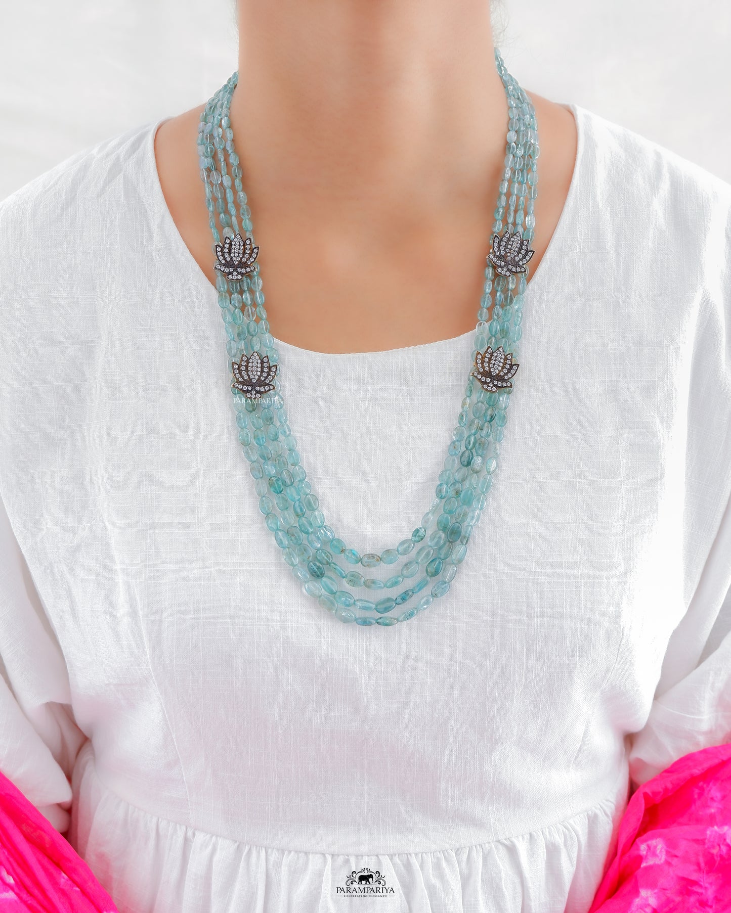 Aquamarine beads necklace adorned with silver zircon lotus motifs.