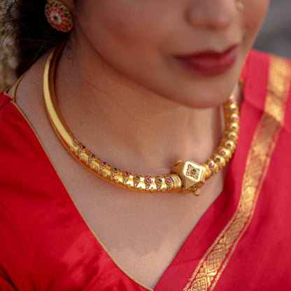 Discover the rich heritage hues of the Boomi Hasli Necklace. This pure silver gold micron plated neckpiece from parampariya.in is a must-have addition to any jewelry collection. Elevate your style with the traditional design and intricate craftsmanship of this Hasli or Kante necklace.